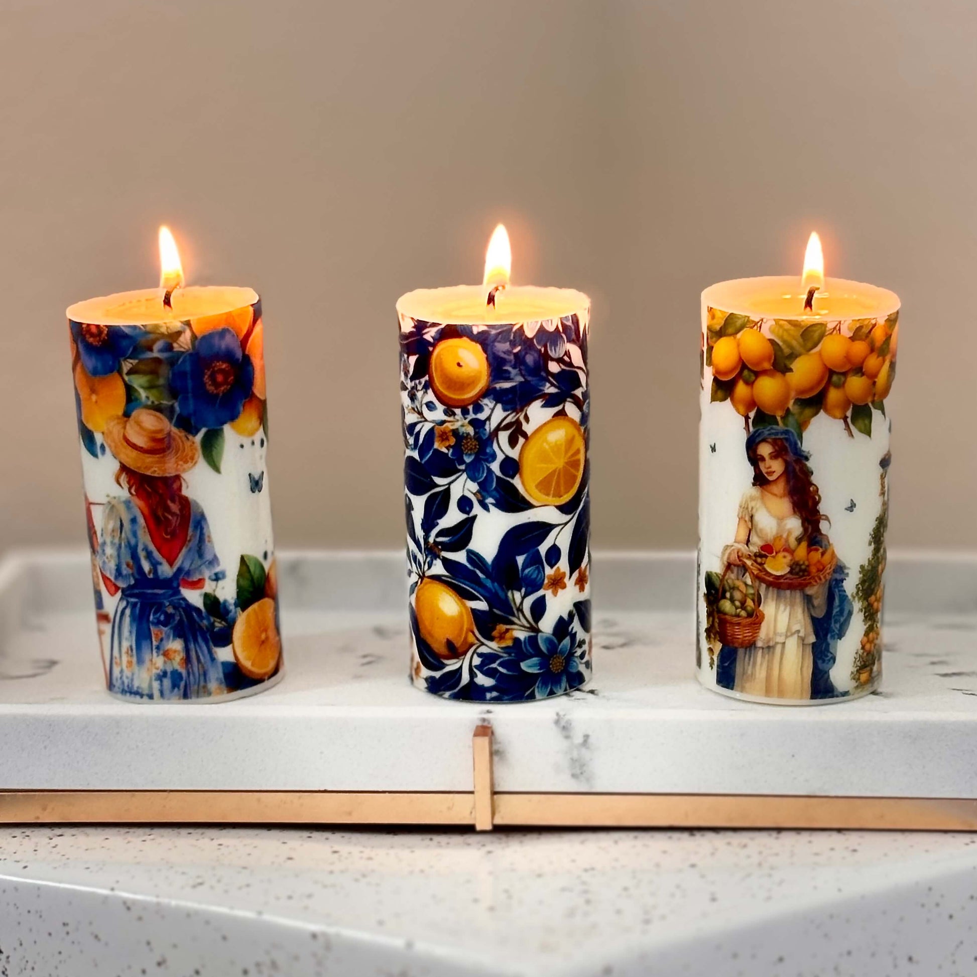 Handmade Italian candles with lemon prints and glossy finish burning on a ceramic tray

