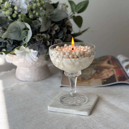 Soy wax pearl candle burning in glass coupe — romantic floral home décor