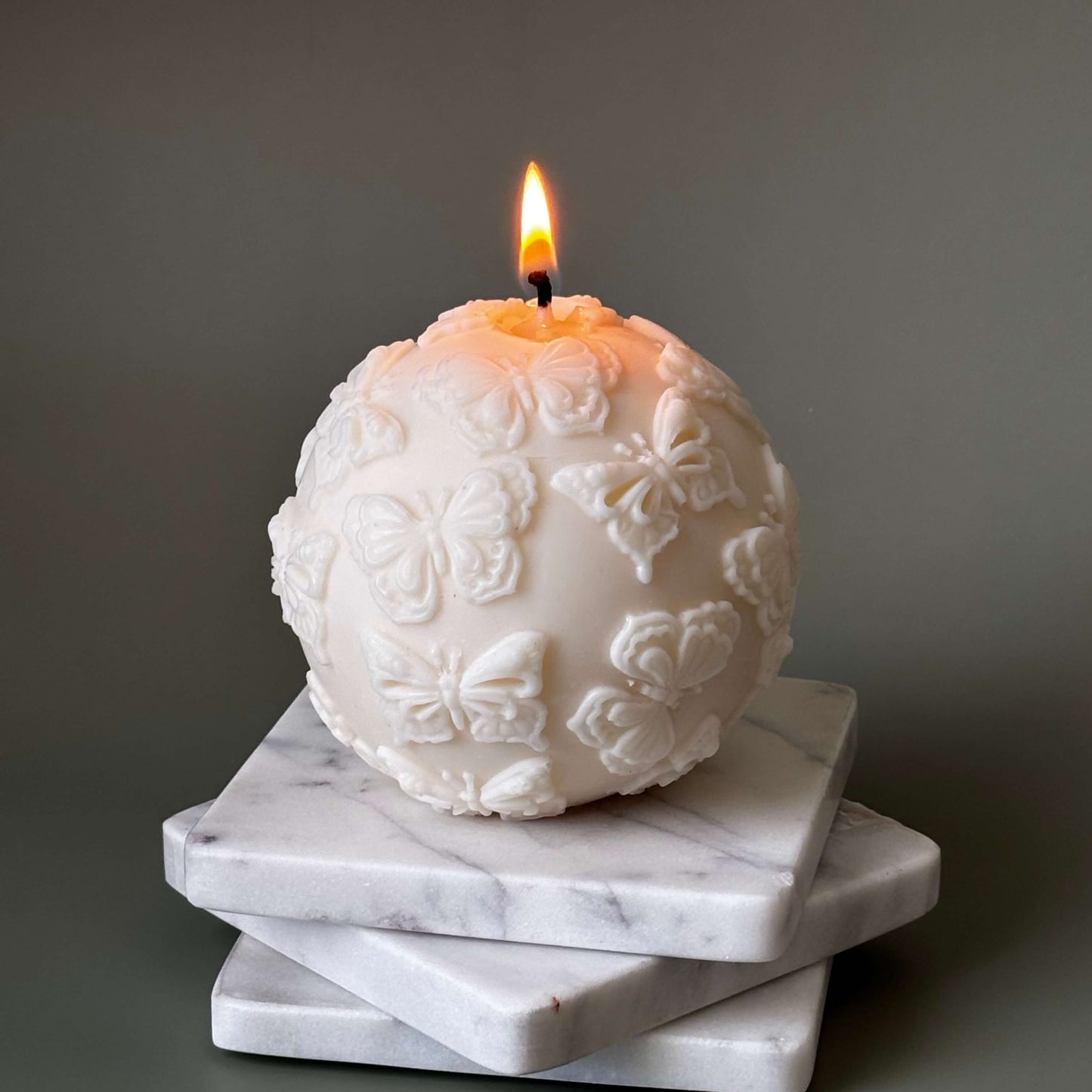 Close-up of sculptural soy candle with butterflies

