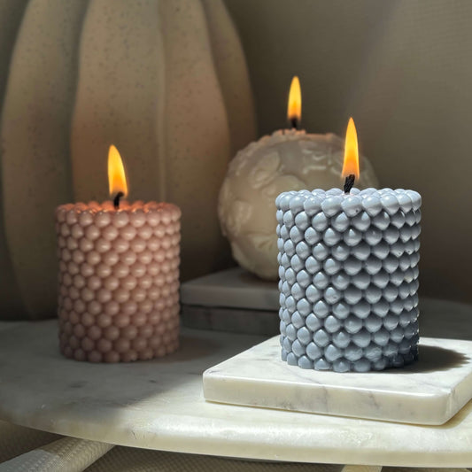 Sculptural soy wax candle in latte brown with soft flame, handmade decor accent for cozy living room or spa corner.
