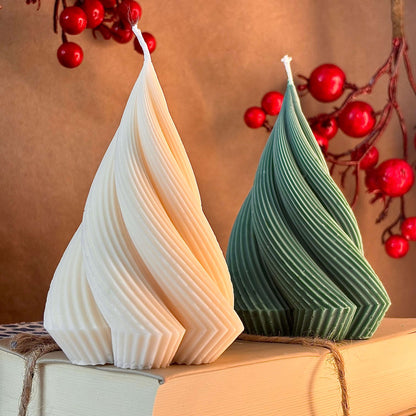 Close-up of ribbed sculptural candles in green and ivory, handmade soy wax, surrounded by red berry branches — Christmas gift decor

