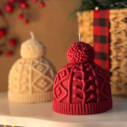 Red and cream knit hat candles styled as Secret Santa gift ideas on a festive table with holiday basket and soft lighting

